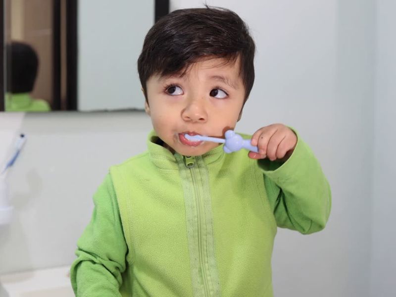 dečak pere zube u toaletu