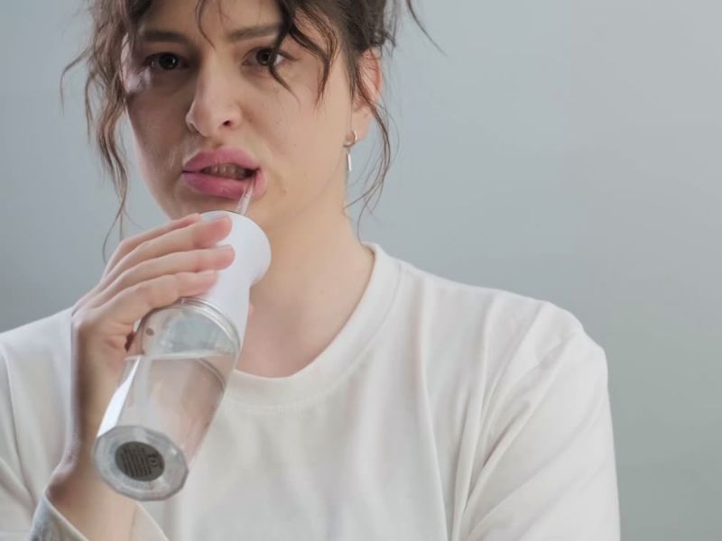 devojka ispira usta sa oralnim irigatorom