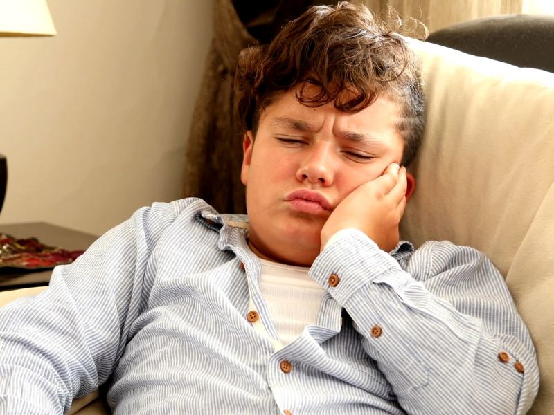 decak se drži od bola u zubima za glavu